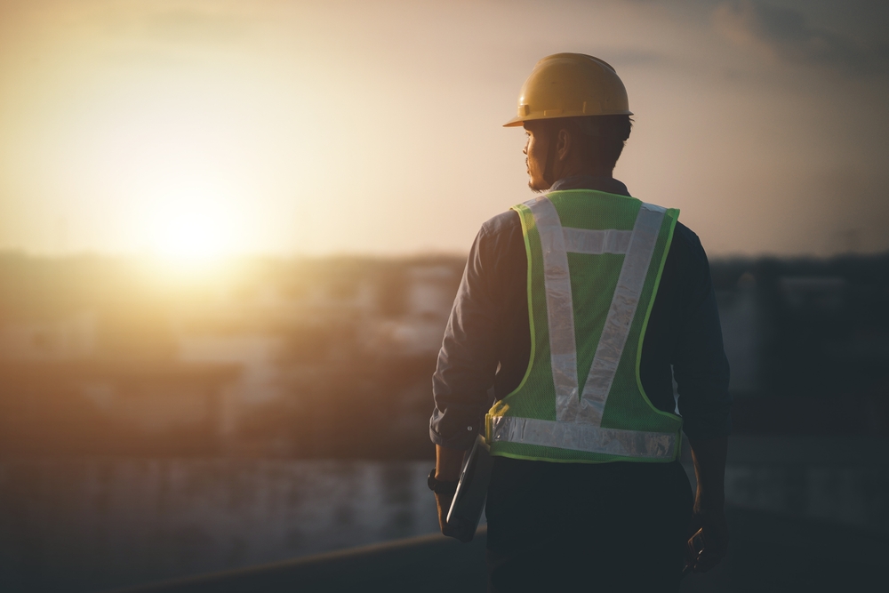 Engineer on a construction site at sunset. Working on the roof